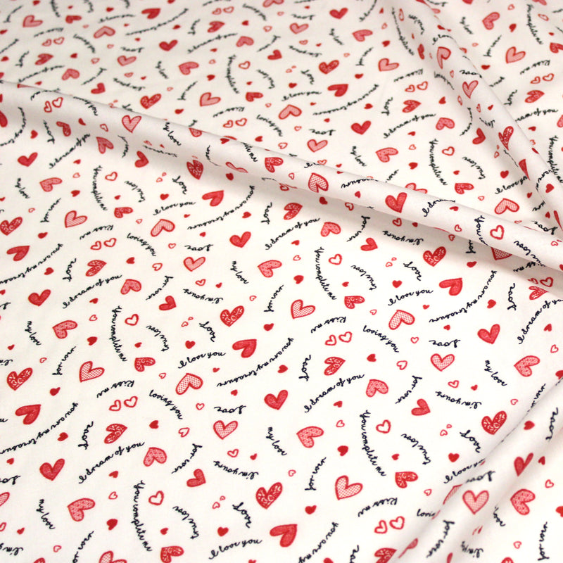 Tissu cotonnade LOVE LOVE, petits cœurs rouges et mots d’amour sur fond blanc