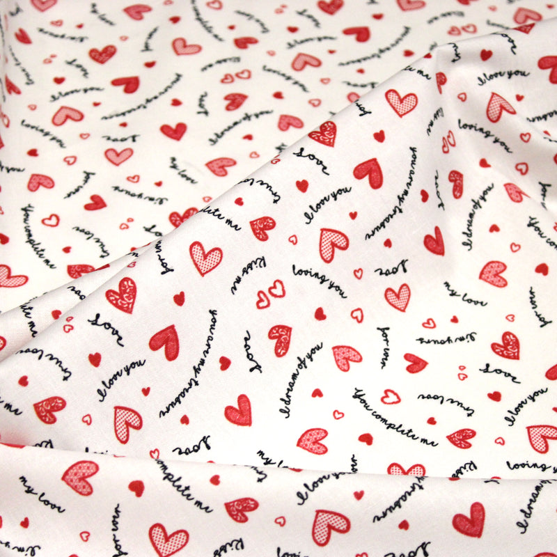Tissu cotonnade LOVE LOVE, petits cœurs rouges et mots d’amour sur fond blanc