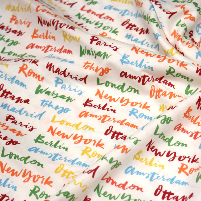 Tissu popeline coton blanc aux noms de ville multicolores, collection VOYAGE - TissusPapi.com