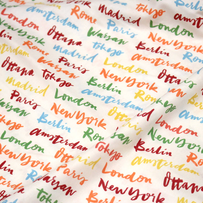 Tissu popeline coton blanc aux noms de ville multicolores, collection VOYAGE - TissusPapi.com