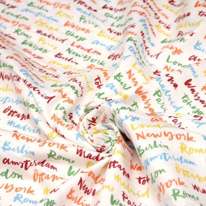 Tissu popeline coton blanc aux noms de ville multicolores, collection VOYAGE - TissusPapi.com