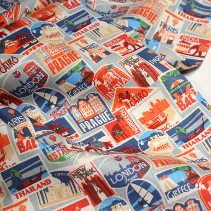 Tissu popeline coton, les autocollants de voyages, tons orange et bleus - TissusPapi.com