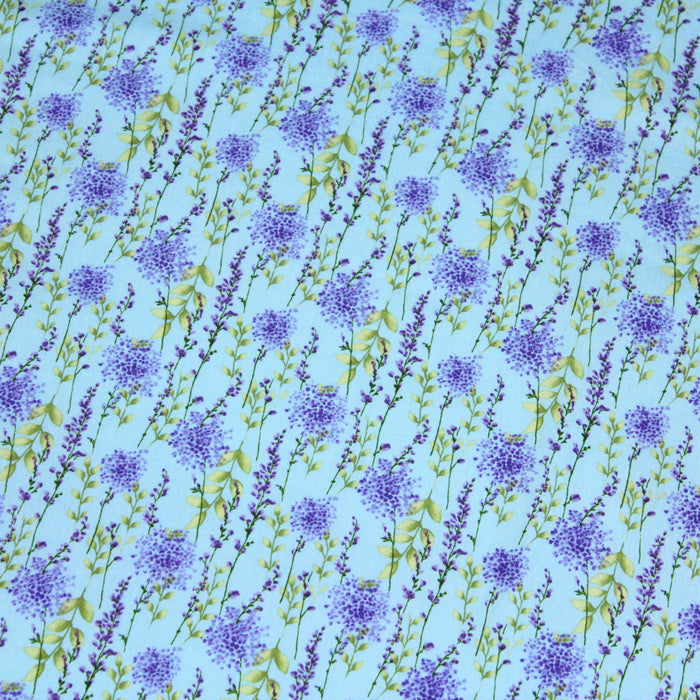 Tissu popeline de coton LAVANDE aux fleurs parme et feuilles vertes, fond bleu ciel