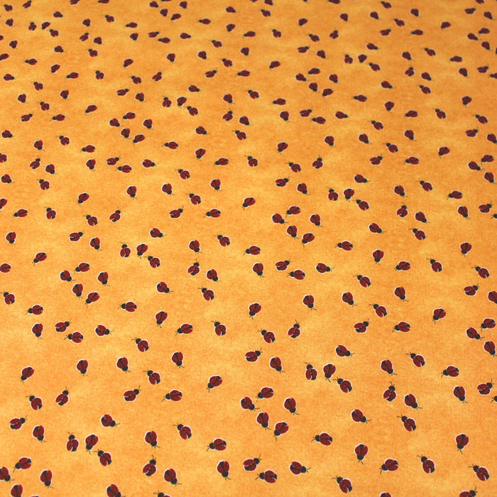 Tissu popeline de coton aux petites coccinelles rouges, fond jaune safran