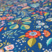 Tissu de coton ANCOLIE aux fleurs et motifs printaniers, fond bleu pétrole - Oeko-Tex