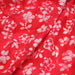Tissu de coton Batik fond rouge clair aux fleurs blanches