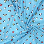 Tissu popeline de coton de Noël aux pingouins de Noël, fond bleu ciel - TissusPapi.com