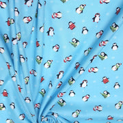 Tissu popeline de coton de Noël aux pingouins de Noël, fond bleu ciel - TissusPapi.com