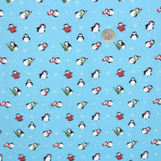 Tissu popeline de coton de Noël aux pingouins de Noël, fond bleu ciel - TissusPapi.com