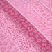 Tissu de coton batik patchwork aux fleurs variées, tons rose et rose fuchsia