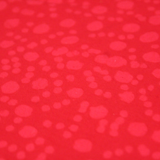 Tissu de coton batik gaufré OCÉANIE aux fleurs et taches rouges clair, fond rouge - tissuspapi