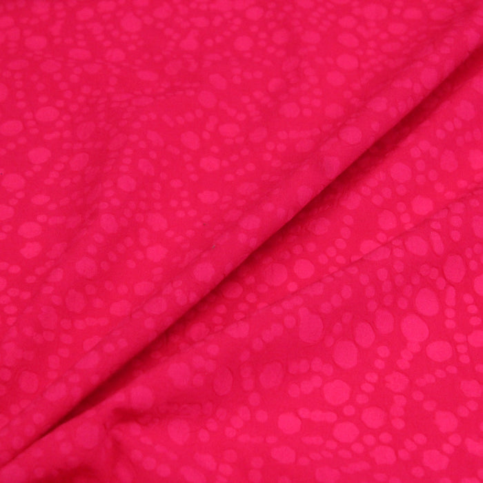 Tissu de coton batik gaufré OCÉANIE aux fleurs et taches roses, fond rose framboise - tissuspapi