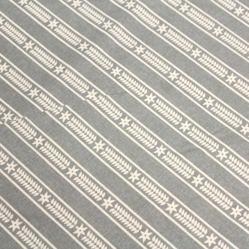 Tissu de coton de Noël scandinave aux étoiles de neiges écrues, fond gris - TissusPapi.com