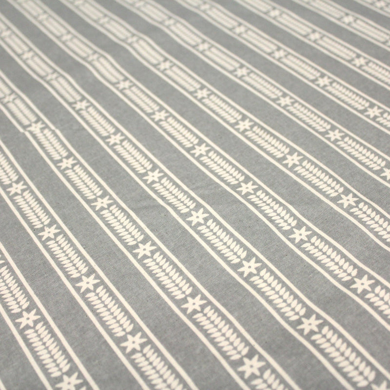 Tissu de coton de Noël scandinave aux étoiles de neiges écrues, fond gris - TissusPapi.com