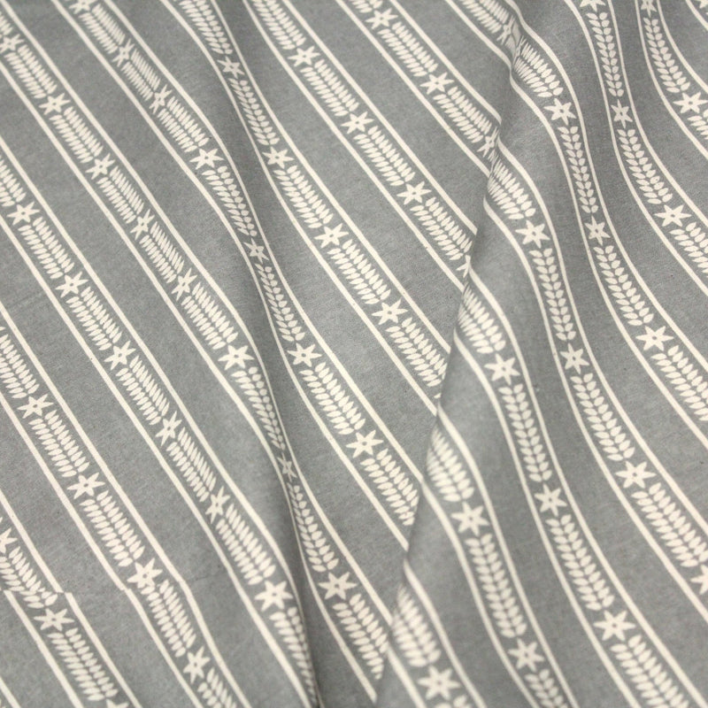 Tissu de coton de Noël scandinave aux étoiles de neiges écrues, fond gris - TissusPapi.com
