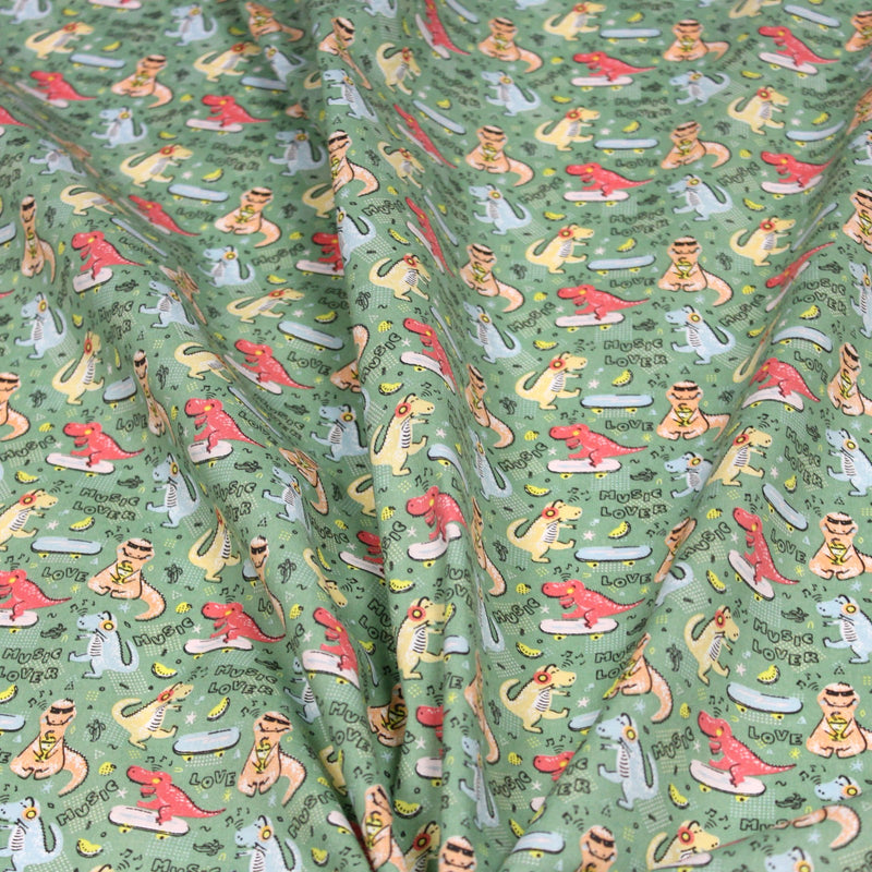 Tissu de coton Dinosaure music lover, fond vert sauge - Oeko - Tex - TissusPapi.com