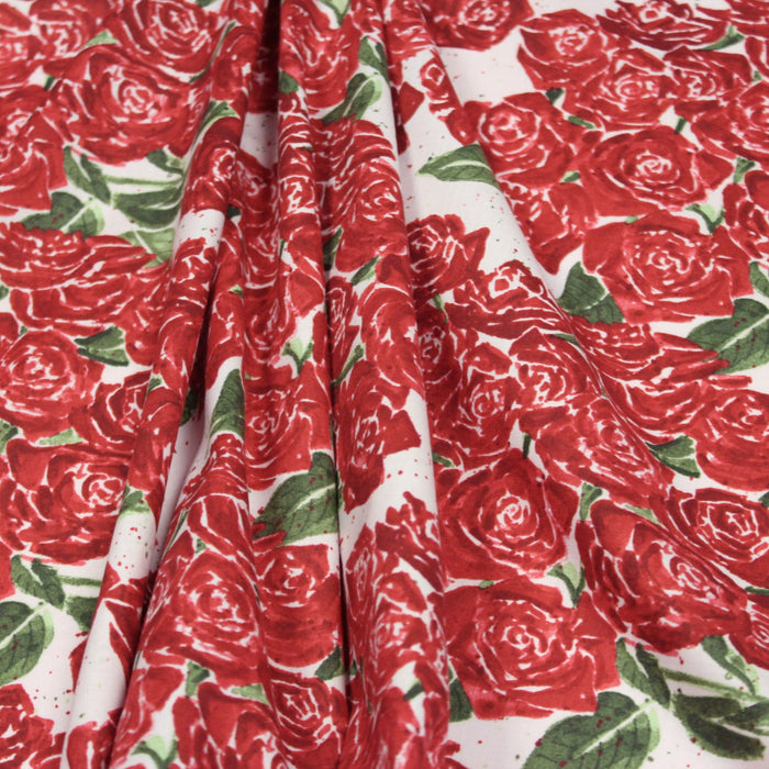 Tissu popeline de coton aux fleurs de roses rouges fond rose pâle - tissuspapi